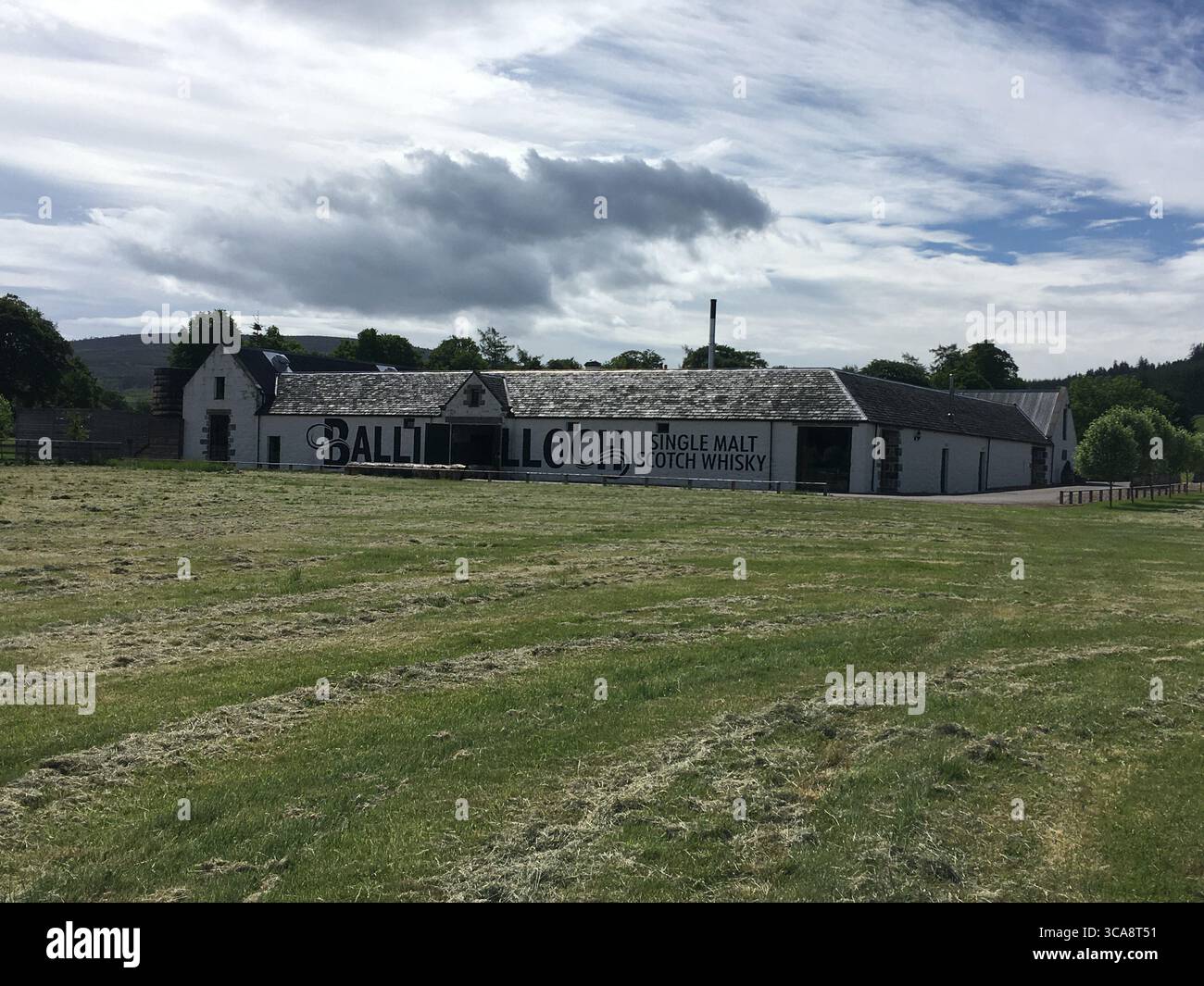 Whisky-Destillerie in Schottland mit Kupferbrennwerken, Eichenfässern und Steinhäusern, die traditionelle Handwerkskunst und ein reiches Erbe zeigen. Stockfoto