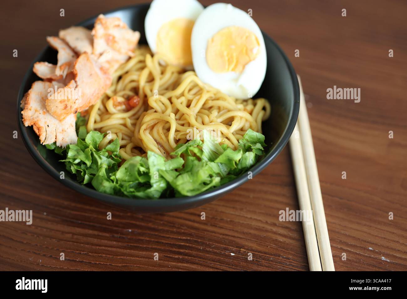 Japanische Ramen mit Ei auf schwarzer Schüssel in Nahaufnahme Stockfoto