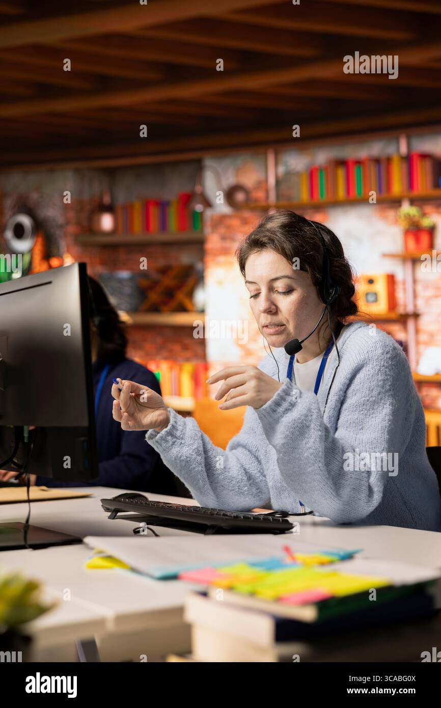 Callcenter-Mitarbeiter im Büro helfen Kunden bei der Lösung ihrer Probleme und bei der Behandlung von Beschwerden. Frau im Kundensupport-Arbeitsbereich mit Headset-Mikrofon, um mit Kunden zu sprechen und bei Bestellungen zu helfen Stockfoto