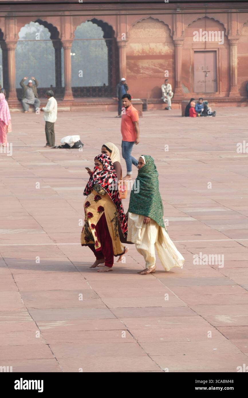 DELHI - 19. November 2019 - muslimische Frauen gehen barfuß durch das große Innere von Jama Masjid, der berühmten Moschee im historischen Zentrum von Alt-Delhi Stockfoto
