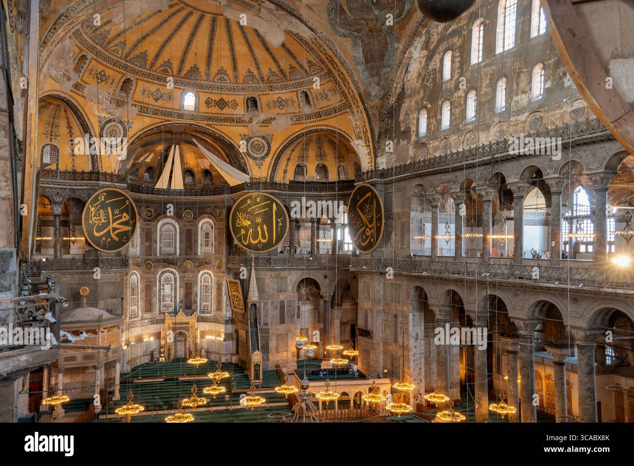 Weite Innenansicht der Hagia Sophia mit Kalligrafiemedaillons und Kronleuchtern – Istanbul, Türkei Stockfoto