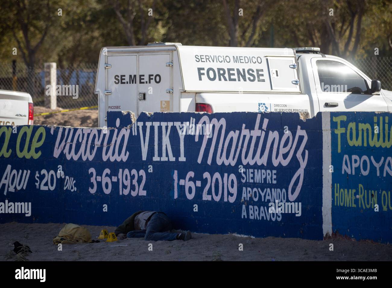 Ein forensisches Fahrzeug an einem Tatort mit einem Wandbild in Ciudad Juarez, ein Beweis für anhaltende Gewalt in der Stadt. Stockfoto