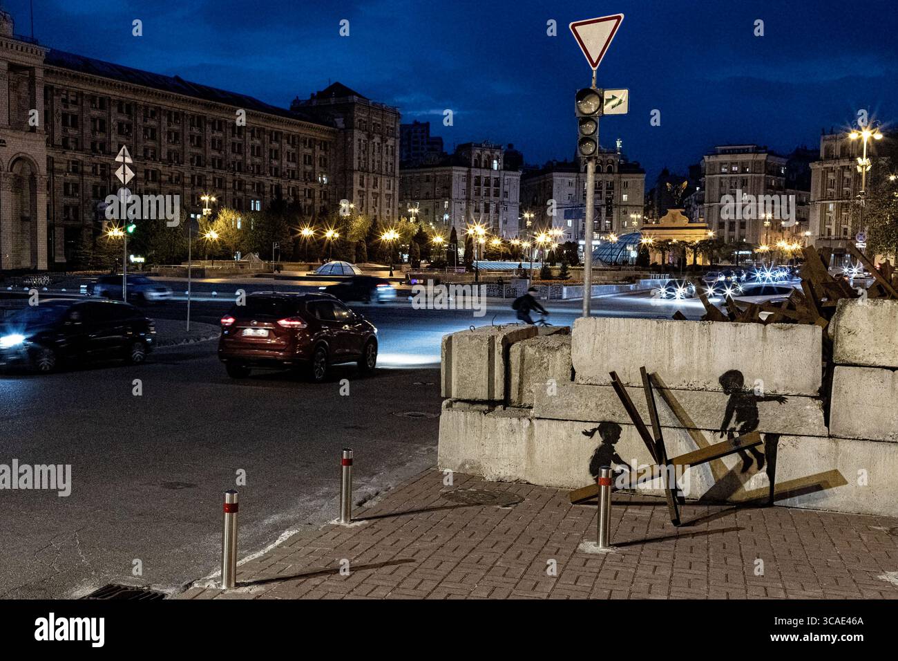 21. April 2023, Kiew, Ukraine: Ein von Banksy inspiriertes Kunstwerk, das Kinder mit einem tschechischen Igel-Panzerabwehrhindernis als Wippe zeigt. (Foto: © Gabriel Romero/ZUMA Press Wire) Stockfoto