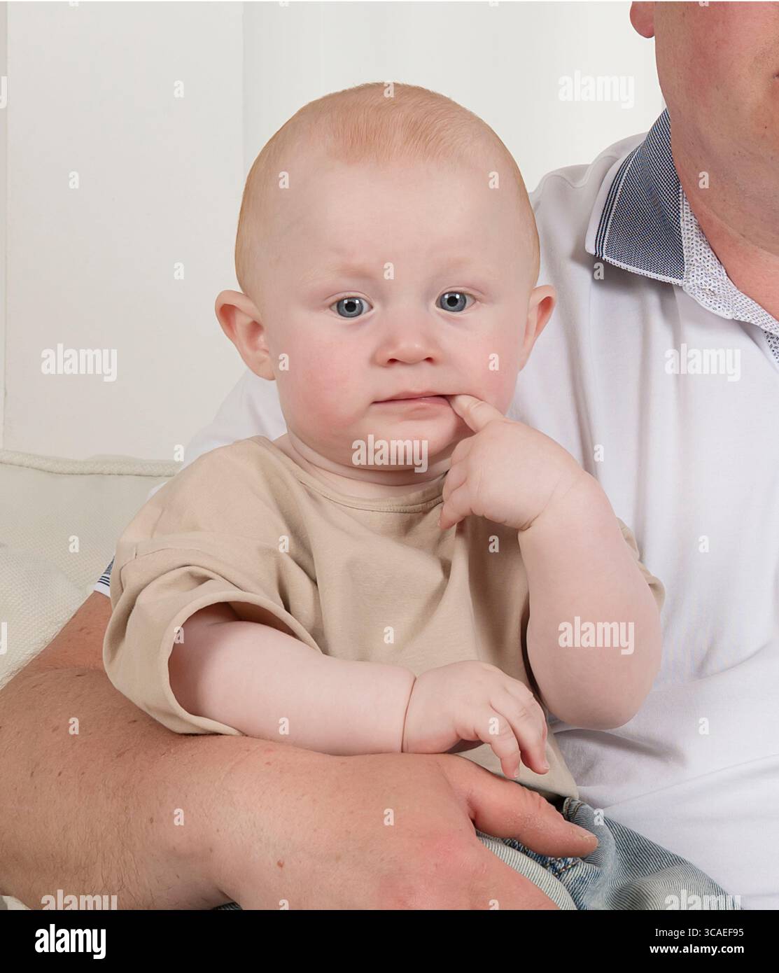 Ein ernstes, vernünftiges Kind, ein Baby lutscht einen Finger, ein Kind steckt einen Finger in den Mund, ein Kind denkt Stockfoto