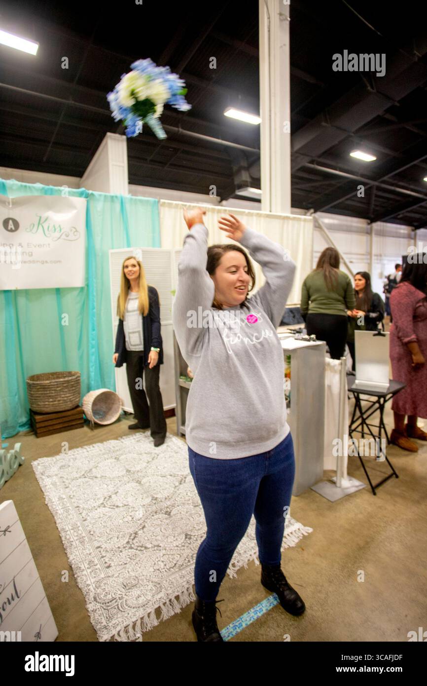 5. Januar 2019, Costa Mesa, Kalifornien: Eine Verlobte junge Frau wirft einen Brautstrauß, der auf den Korb im Hintergrund zielt, um sich für ein Lotterieticket auf einer Brautmesse in Costa Mesa, CA. Zu qualifizieren (Credit Image: © Spencer Grant/ZUMA Press Wire) Stockfoto