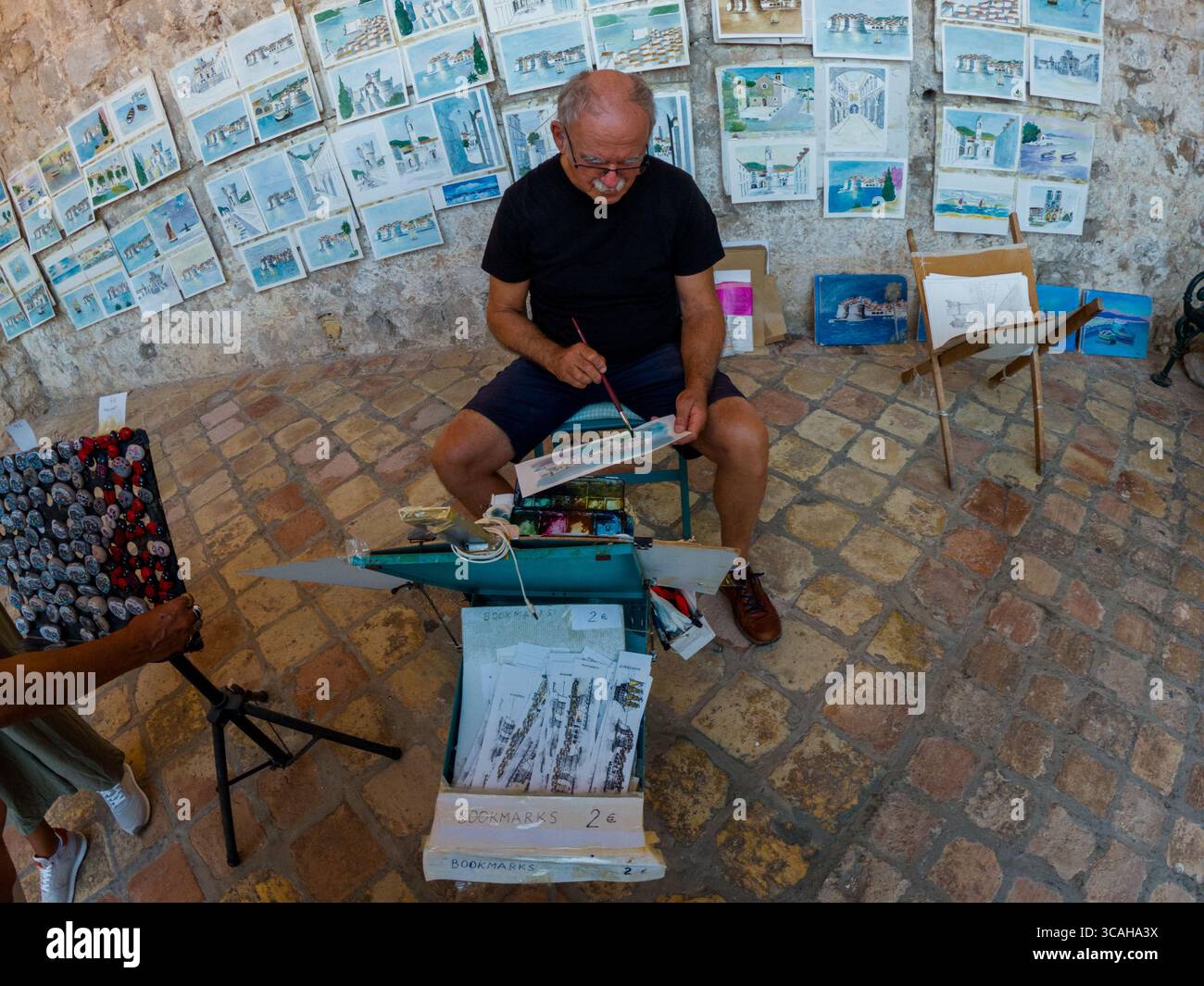 Dubrovnik, Kroatien - 14. September 2023: Ein Künstler malt Dubrovnik Szenen für Touristen. Er verkauft Lesezeichen und Gemälde der Stadt, um zu leben Stockfoto