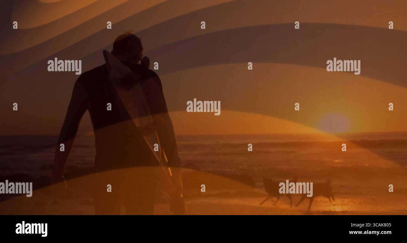 Walking man trägt Surfbrett unter Arm am Strand bei Sonnenuntergang, mit Neoprenanzug und zwei Liegestühlen Stockfoto