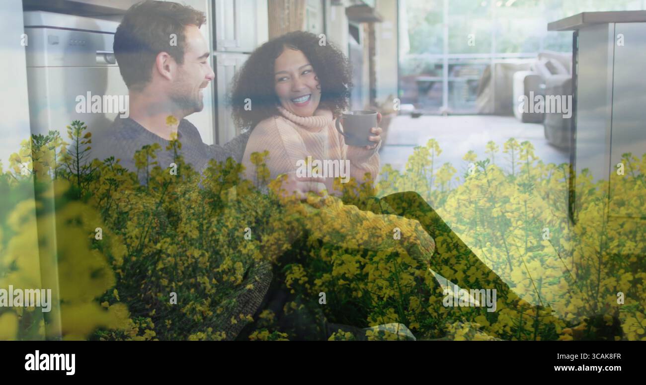 Halten Becher Paar mit Pullover und Hemd, lehnt sich an die Kücheninsel mit Schiebetür Stockfoto