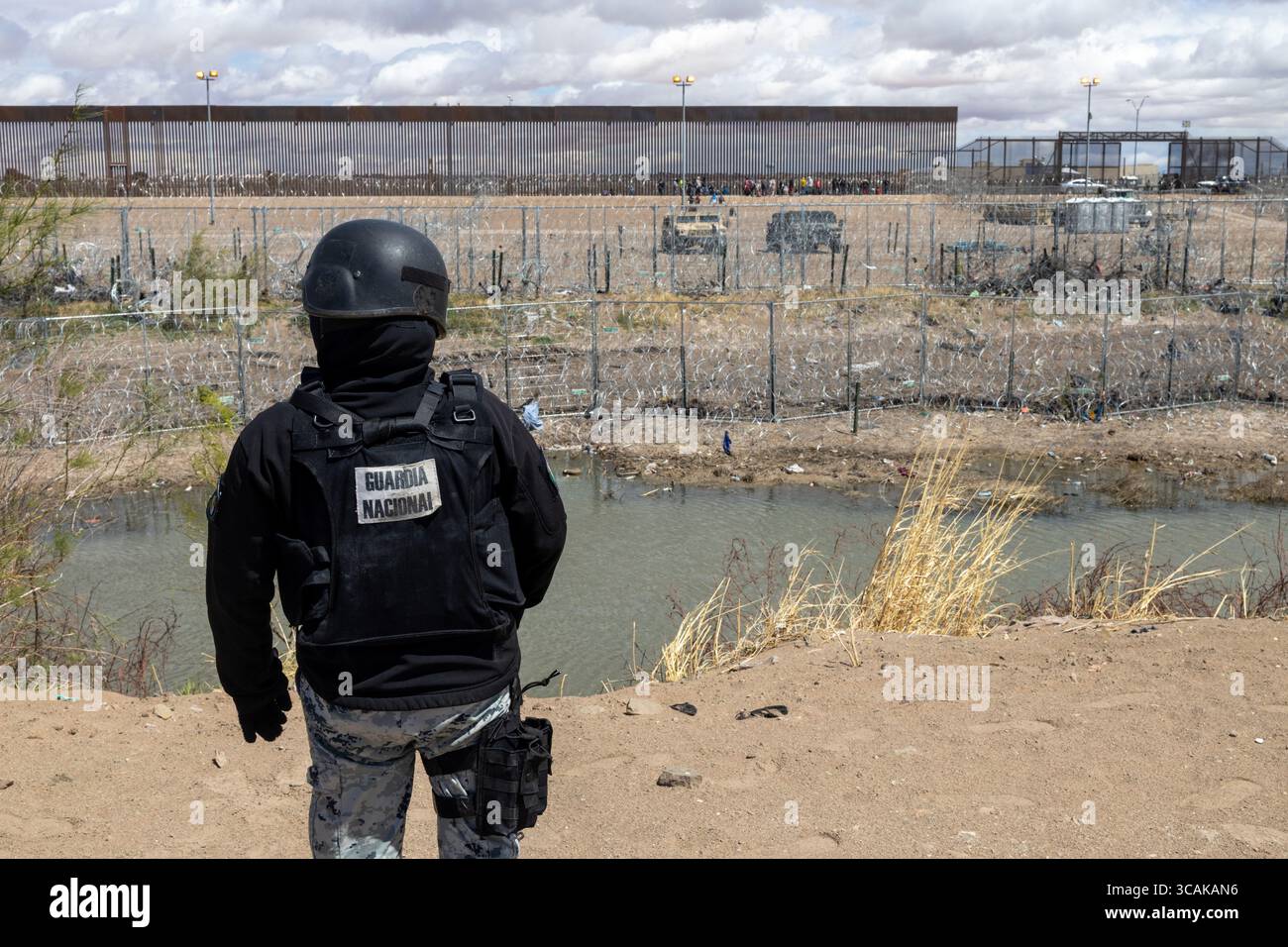 Hunderte von Migranten campen am Rio Grande an der Grenze zwischen Mexiko und den Vereinigten Staaten, während die mexikanischen Migrationsbehörden eine Operation in der Region durchführen. Die texanische Nationalgarde verstärkt die Sicherheit mit Stacheldraht und Maschendrahtzaun, um Migranten daran zu hindern, zu überqueren. Im Fluss gefangen, können sie aus Angst vor Abschiebungen keine Lebensmittel kaufen und warten auf eine Gelegenheit, unbemerkt zu überqueren. Stockfoto