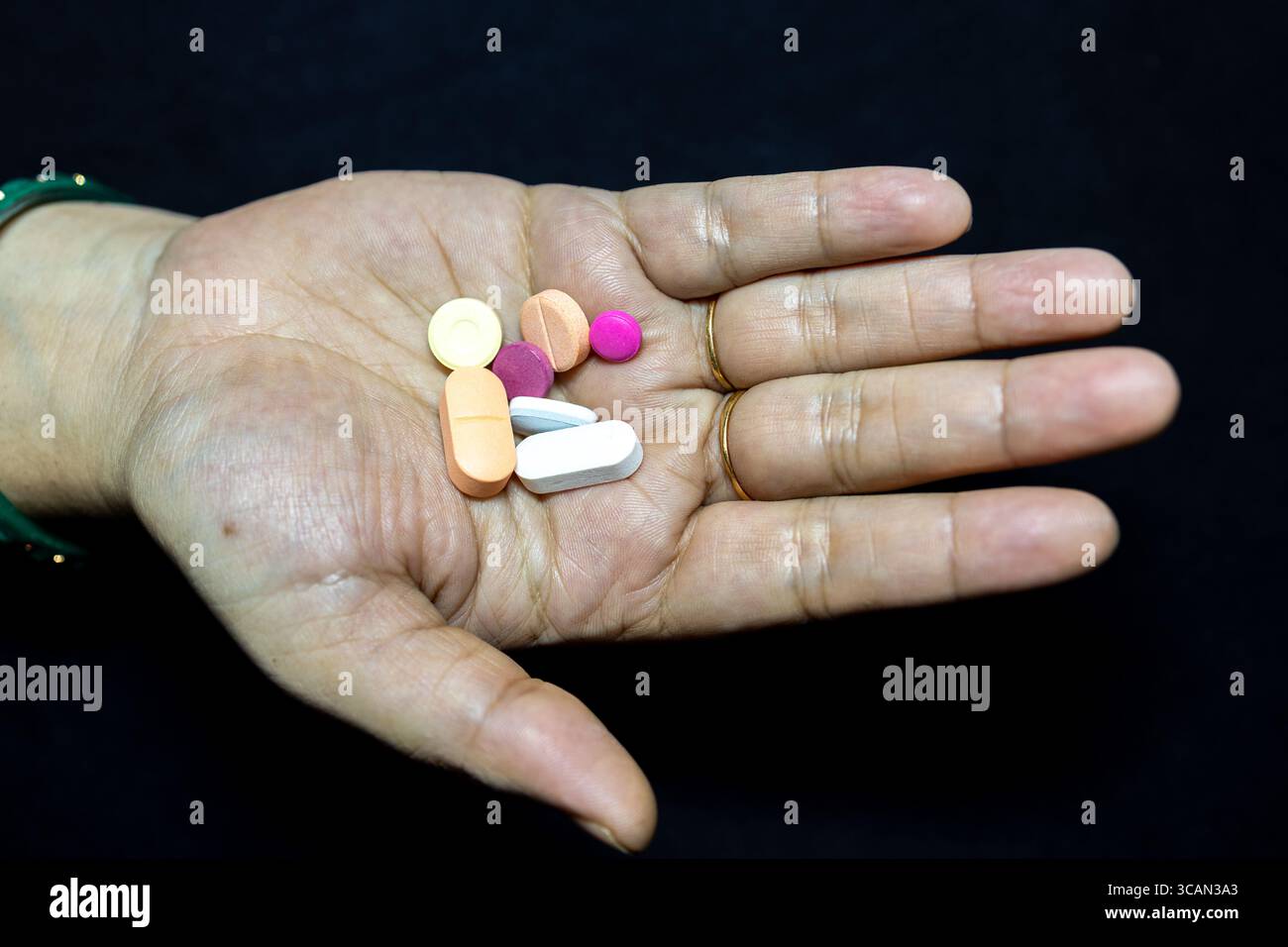 Gesundheitskonzept mit Erwachsenenhand und Pillen bei Innenbeleuchtung Stockfoto