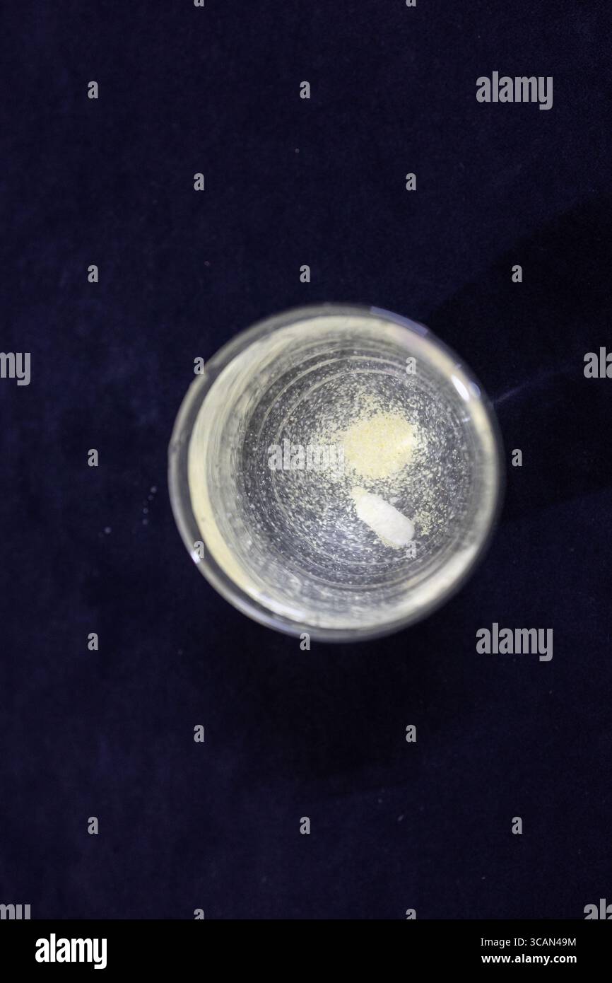Die Lösung von Arzneimitteln in transparentem Wasserglas im Innenraum Stockfoto