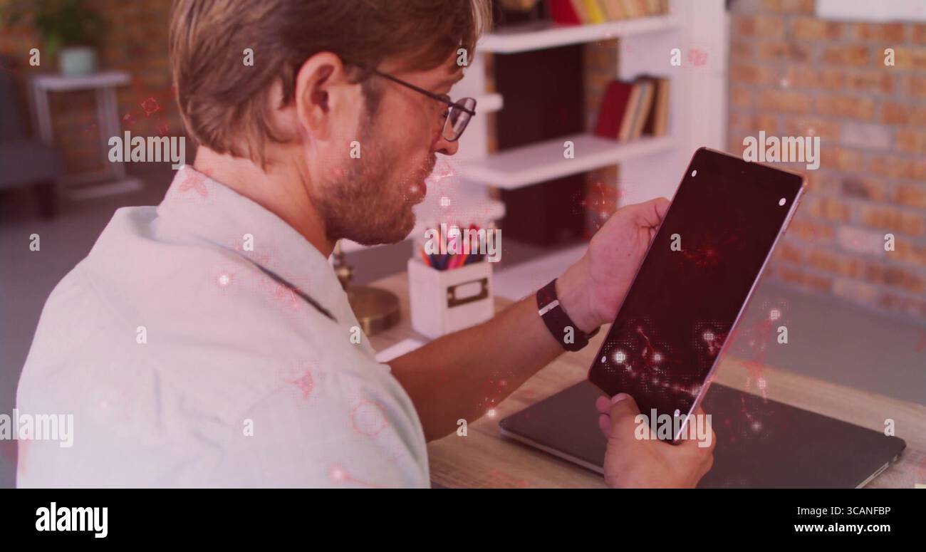Hält Tablet-Mann mit Hemd und Brille am Schreibtisch im Heimbüro, mit geschlossenem Laptop und Organizer Stockfoto
