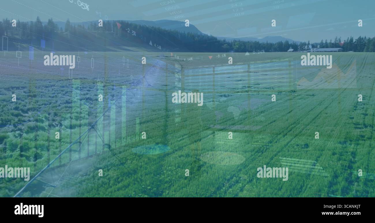 Ausfahrbarer Mittelschwenkarm zur Besprengung grüner Erntegutreihen auf das Feld des Betriebs, mit Betriebsgebäude Stockfoto