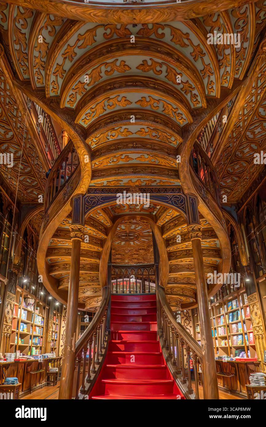 Spektakuläre Verzierte Decke Und Rote Treppe Im Historischen Lello Bookstore Porto Portugal. Komplexe Neogotische Architektur, Geschnitzte Holzdetails, Beleuchtet Stockfoto