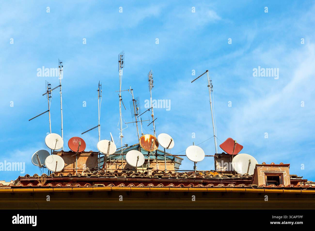 Viele Satellitenantennen auf dem Haus vor blauem Himmel in Italien. Stockfoto