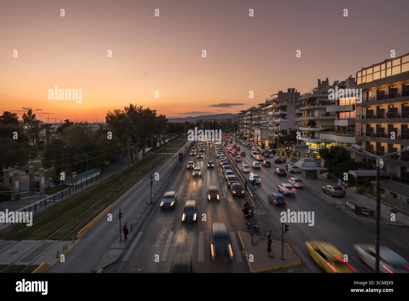Athen, Griechenland - 2. Mai 2025: Sonnenuntergang über Athen: Die Autos strömen die Leoforos Poseidonos Avenue herunter Stockfoto