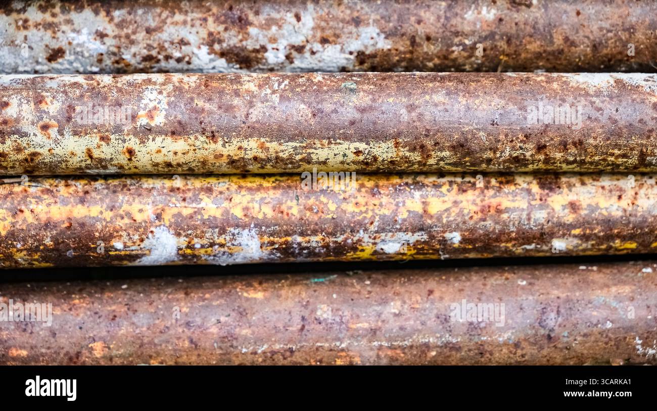 Nahaufnahme alter rostiger Wellblechoberfläche mit Spuren von blauer Farbe und intensiver Korrosionsstruktur Stockfoto