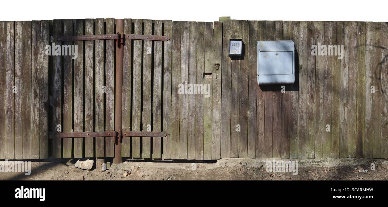 Ein krummer, hässlicher hölzerner, ländlicher Zaun mit einem Postfach oben. Sonniger Frühlingstag Panoramaaufnahme Stockfoto