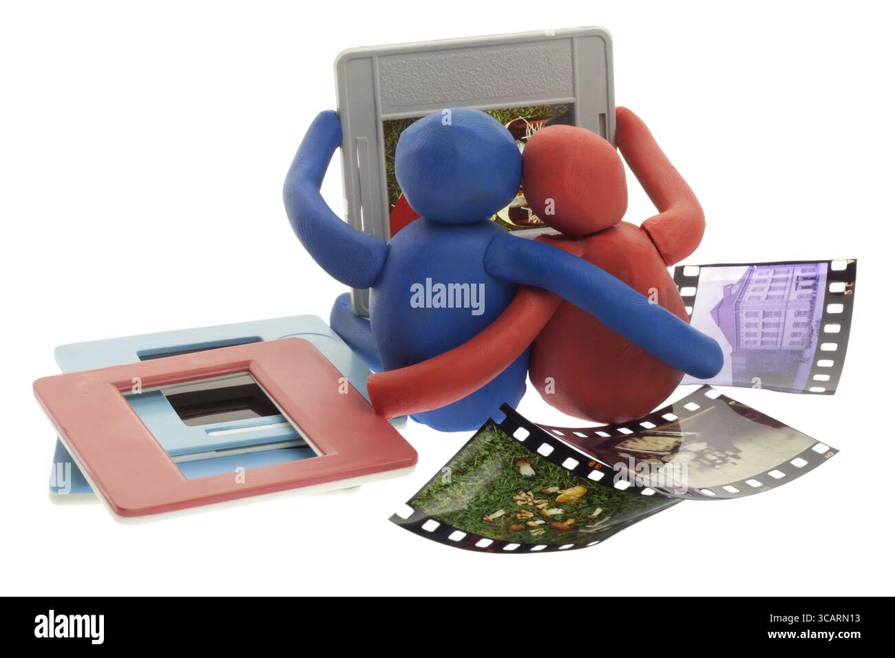 Spielzeug-Knetmasse-Mann und die Frau suchen alte Fotos Dias. Das Konzept der Erinnerung der Vergangenheit Stockfoto