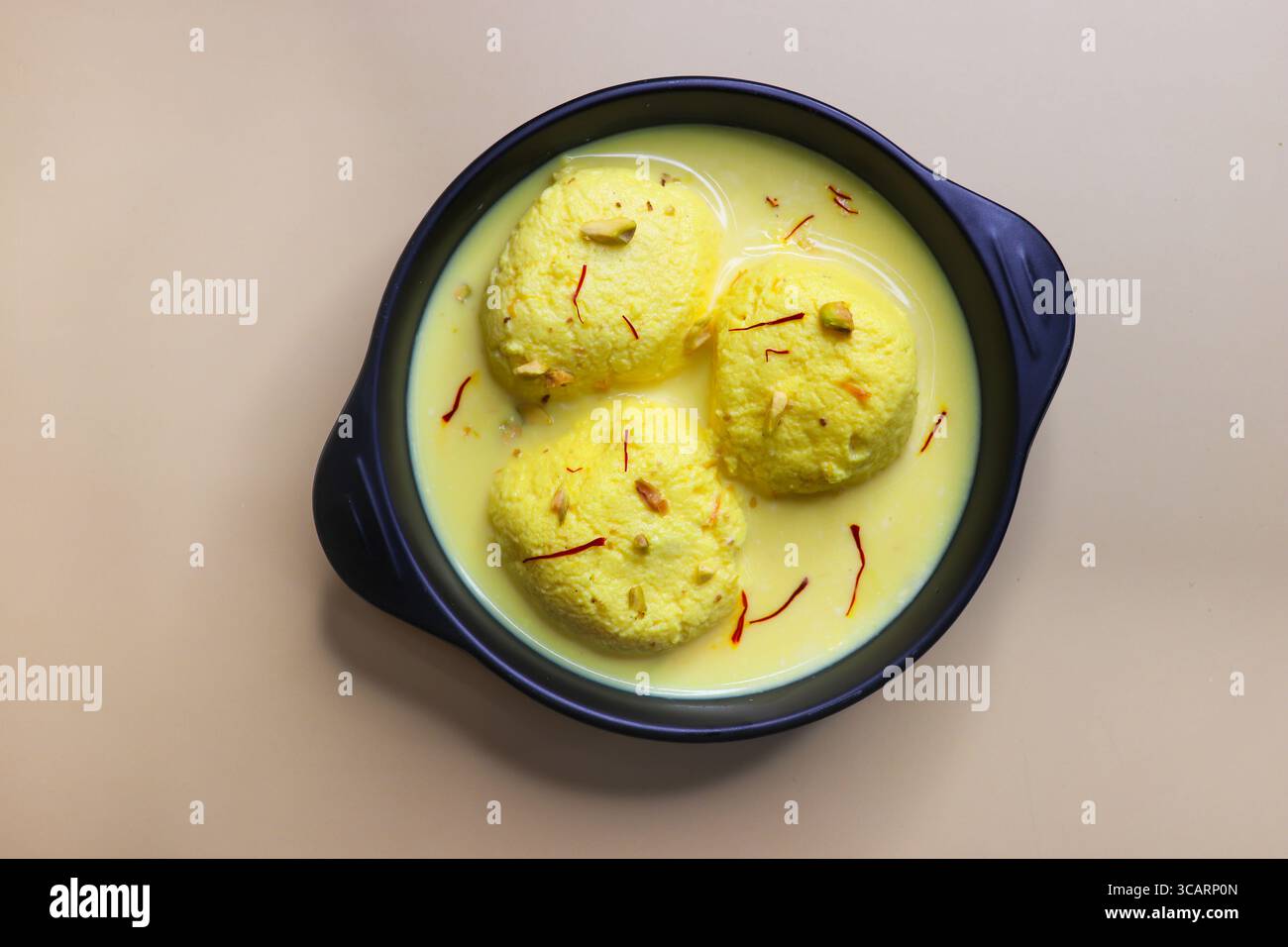 Rasmalai ist ein weiches, schwammiges Dessert aus Chenna oder Paneer. Eingeweicht in safrancremiger Milch, garniert mit gehackten Pistazien und Mandeln. Stockfoto