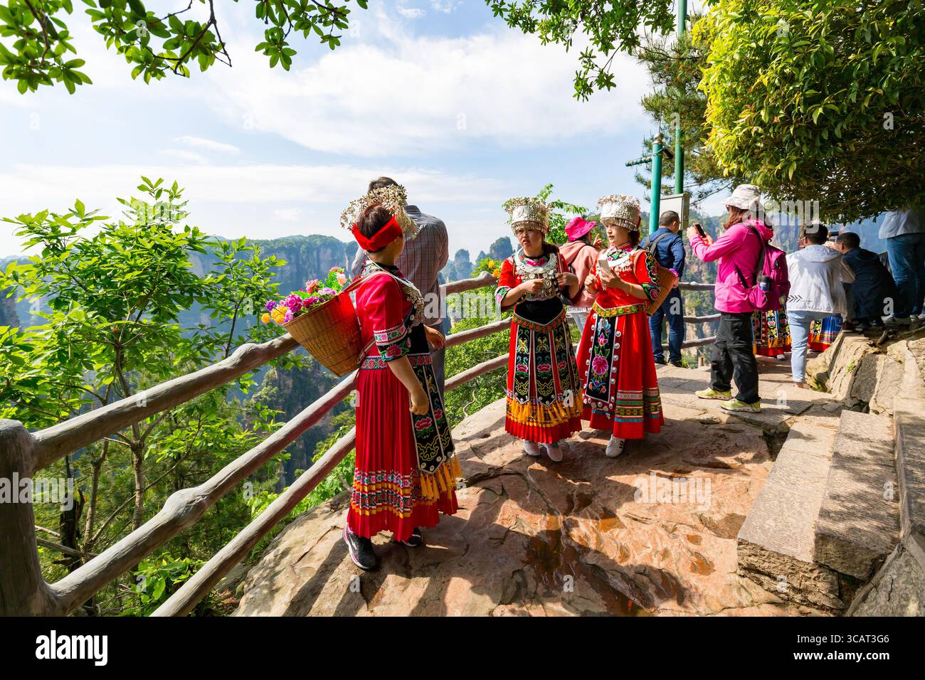 Zhangjiajie, Wulingyuan, China - Mai 2019: Schöne Frauen in chinesischer roter Nationalkleidung posieren vor der natürlichen Landschaft mit Steinsäulen Quarz m Stockfoto