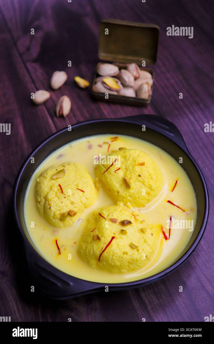Rasmalai ist ein weiches, schwammiges Dessert aus Chenna oder Paneer. Eingeweicht in safrancremiger Milch, garniert mit gehackten Pistazien und Mandeln. Stockfoto