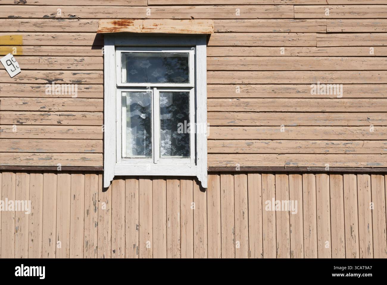 Altes schmutziges weißes Fenster in der alten Holzstruktur. Das Alterskonzept Stockfoto