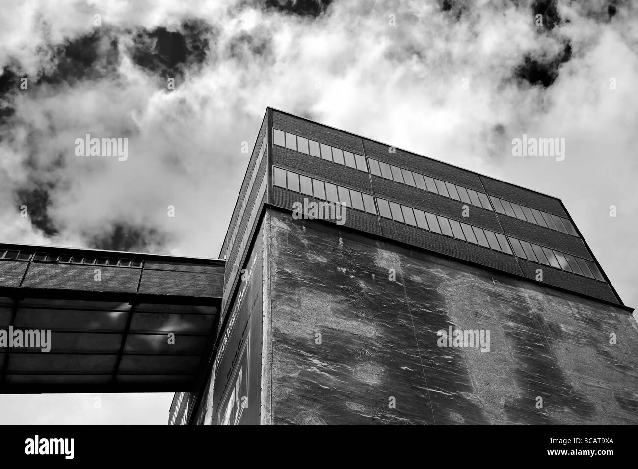 Ein auffälliges Schwarz-weiß-Foto eines modernen Industriegebäudes, das ein einzigartiges architektonisches Design mit großen Fenstern und einer strukturierten Kontur zeigt Stockfoto