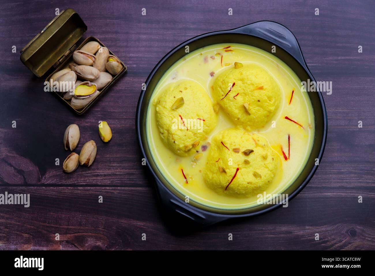 Rasmalai ist ein weiches, schwammiges Dessert aus Chenna oder Paneer. Eingeweicht in safrancremiger Milch, garniert mit gehackten Pistazien und Mandeln. Stockfoto
