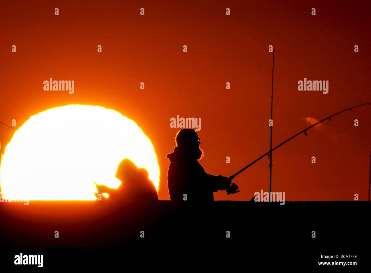 24. Oktober 2023, Isle of Palms, SC, Vereinigte Staaten: Fischer, die von Sonnenaufgang umgeben sind, warten am Isle of Palms Pier, 24. Oktober 2023 in Isle of Palms, South Carolina, auf den Fisch. (Bild: © Richard Ellis/ZUMA Press Wire) Stockfoto