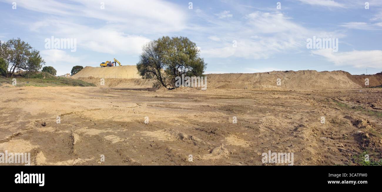 Der Anfang des großen Bauens im Wald. Bagger entfernten die oberste Erdschicht, es gab einen Ton und Sand. Panoramabild aus mehreren Aufnahmen Stockfoto