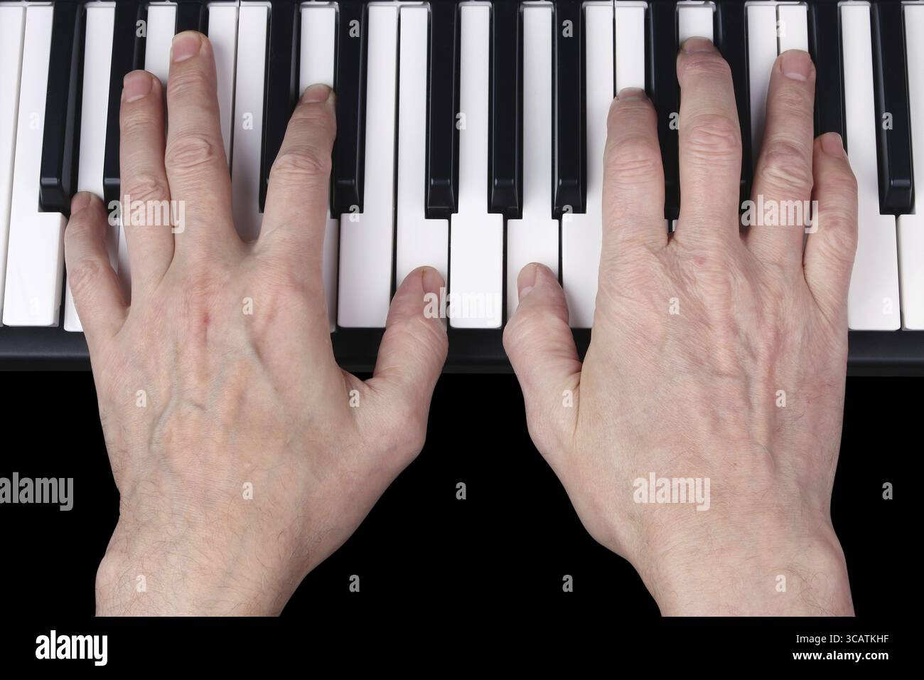 Ein älterer Rentner spielt eine alte Melodie auf dem Keyboard des Synthesizers. Studio-Aufnahme für menschliche Augen. Teilweise isoliert auf Schwarz mit Patch Stockfoto