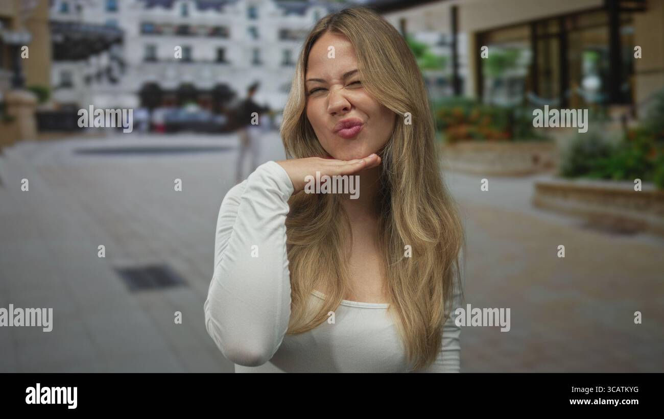 Die Frau legt die Lippen und legt die flache Hand unter das Kinn, während sie nach oben auf die Stadtstraße blickt; spielerischer Zuneigung Humor Spaß. Stockfoto