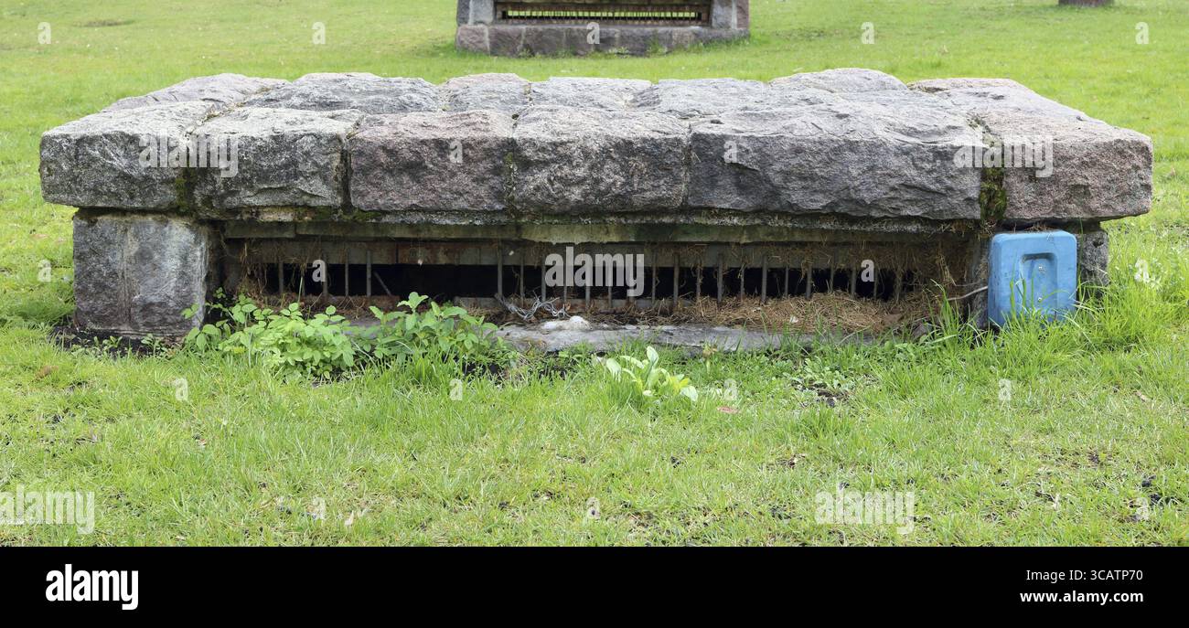 Luftschächte einer alten Luftschutzhütte im Stadtpark. Für das Erscheinungsbild bestehen Abdeckungen aus Granitsteinen Stockfoto