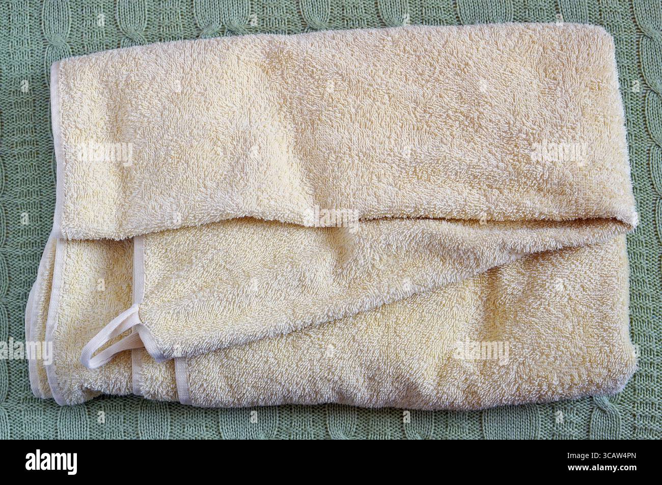 Terry gelb trockenen sauberen Handtuch liegen auf einem Wolle gestrickt Bett Bettdecke Stockfoto