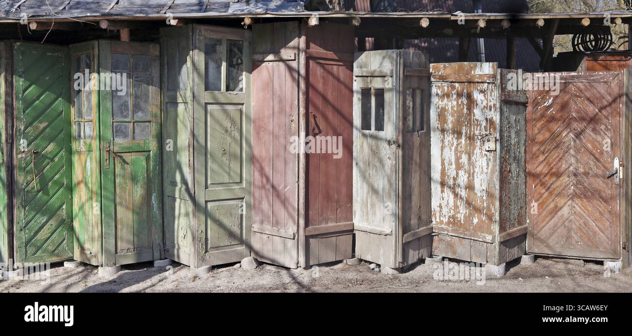 Verrottete Holztüren in dem kleinen Landhaus ohne Namen. Sonniger Frühlingstag Panoramaaufnahme im Freien Stockfoto