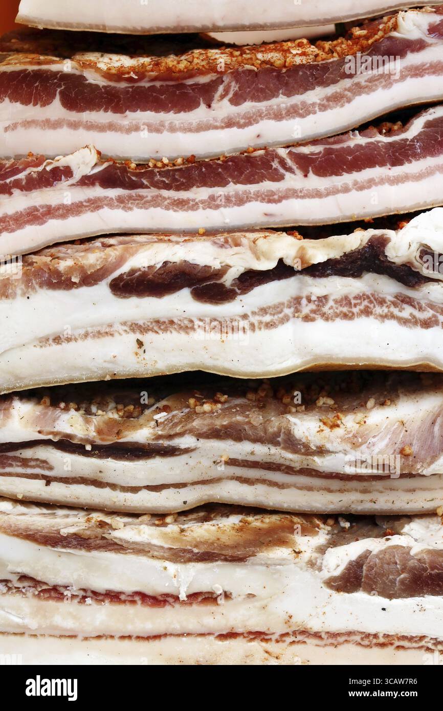 Querschnitte von großen Stücken von geräuchertem gesalzenen Schmalz. Fleisch wird mit Gewürzen, Pfeffer und Knoblauch zubereitet. Outdor Frühling Schuß Stockfoto