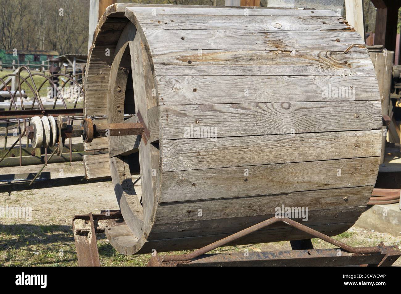 Eine große hölzerne Trommel für landwirtschaftliche Maschinen liegt in der Nähe des Dorfes Scheune installiert. Sonniger Frühlingstag Außenaufnahme Stockfoto