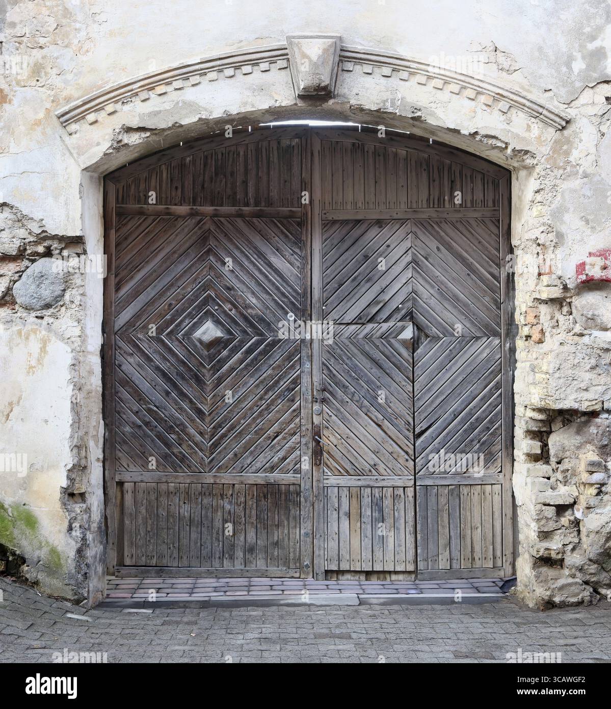 Die Straße hölzerne alte Tore zum alten öffentlichen mittelalterlichen Backsteintempel und Kirche. Frühling bewölkter Tag draußen Stockfoto