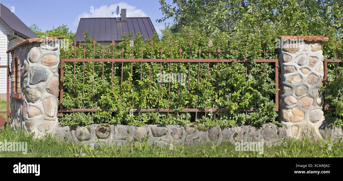 Fragment des Dorfes Zaun. Der ganze Granit Steine und Gitterrost. Mai Tag Panoramablick auf die Landschaft Stockfoto