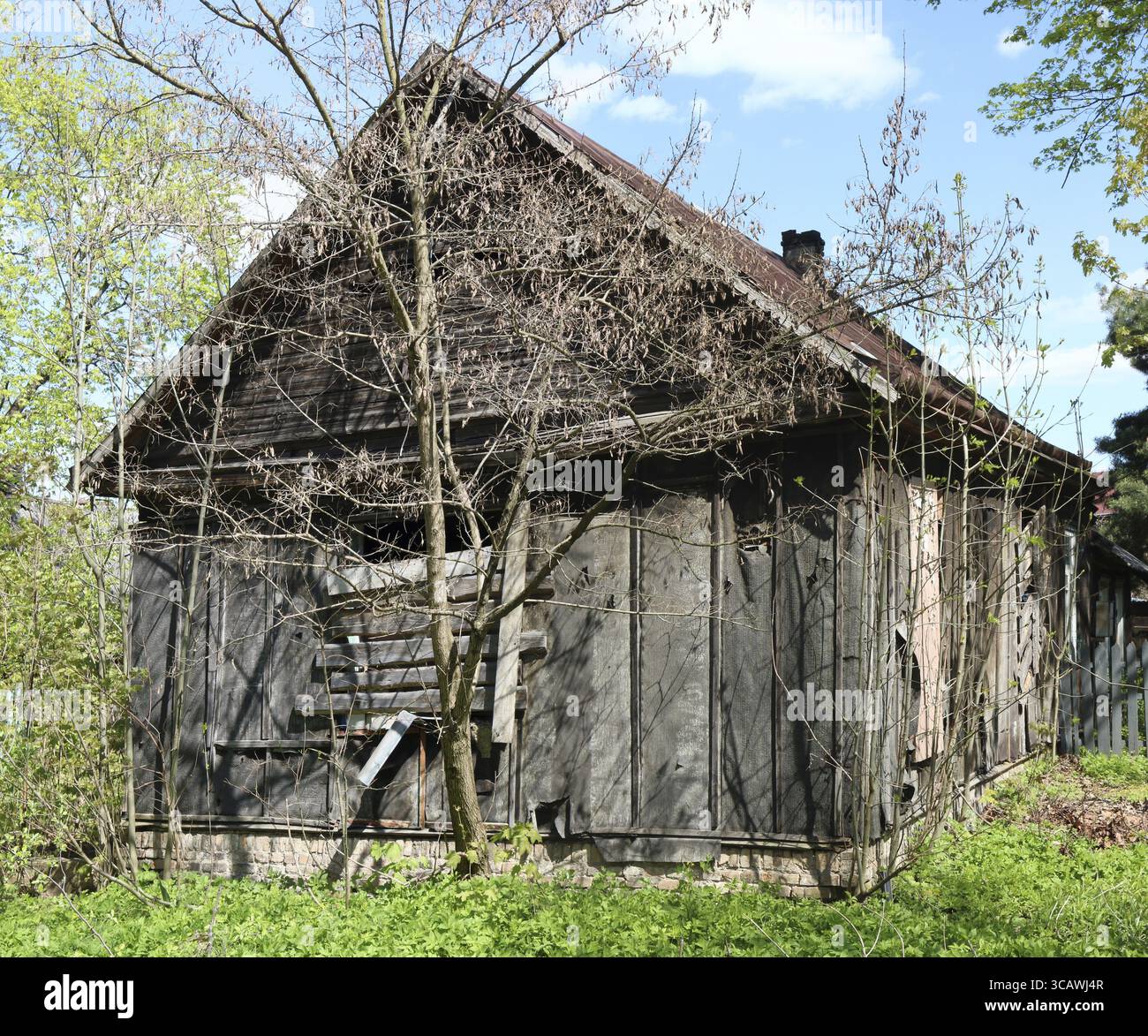Eine verlassene gebrochen Holzhaus mit Zugenagelten Fenstern in einem vergessenen Dorf. Sonniger Frühlingstag gedreht Stockfoto