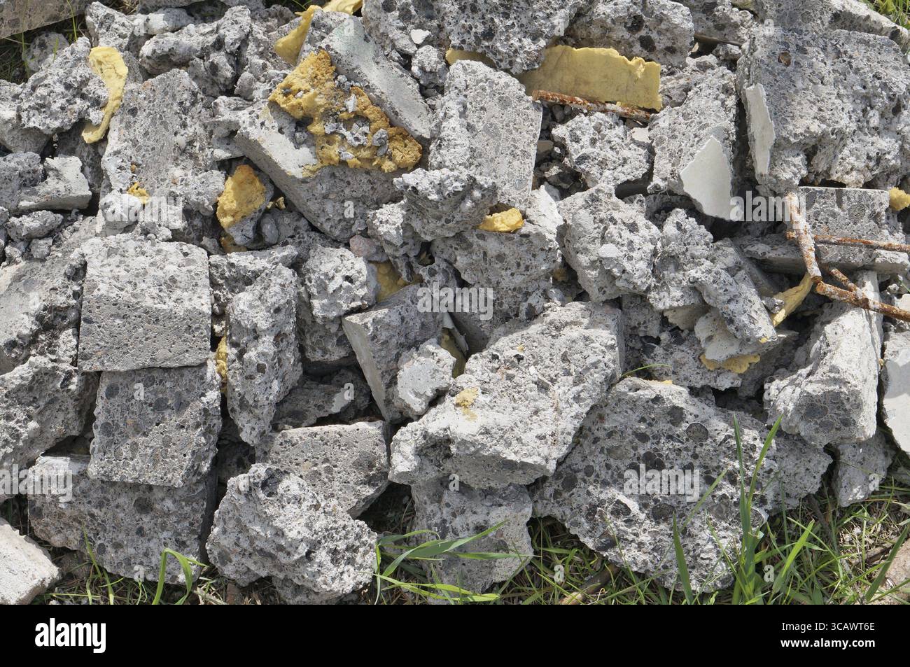 Stücke der gebrochenen Schlacke Beton lag auf dem Gras. Sonniger Frühlingstag im Hintergrund Stockfoto