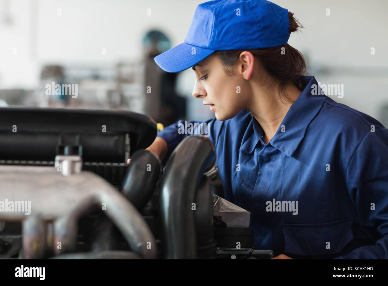 Motorraum des Autos wird in der Automobilwerkstatt mit Schläuchen, Metallteilen und Werkzeugen überprüft Stockfoto