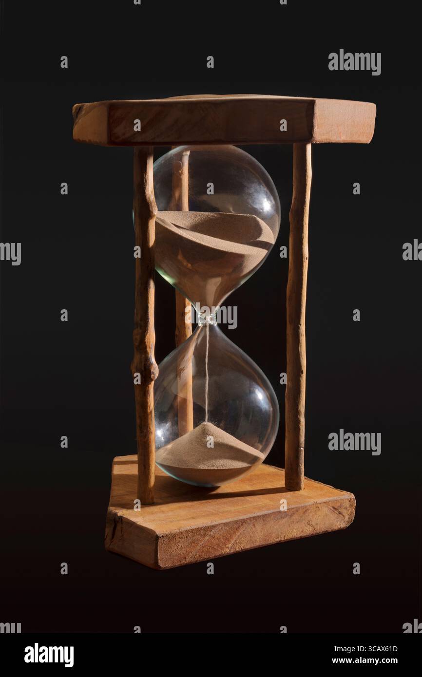 Ein großes Sanduhrglas vor schwarzem Hintergrund Stockfoto