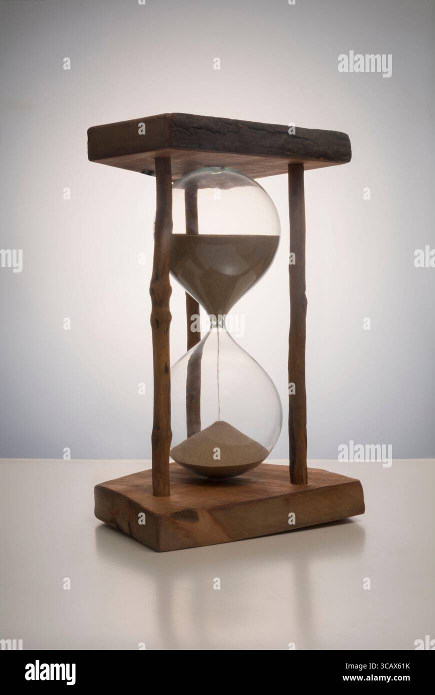 Ein großes Sanduhrglas in einem Holzständer Stockfoto