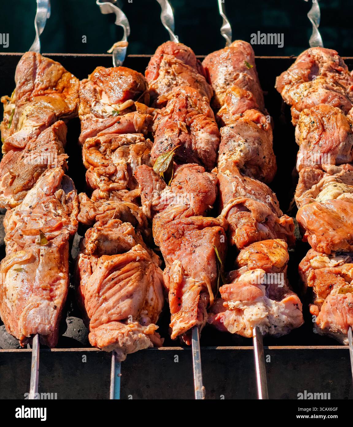 Herzhafte gegrillte Fleischspieße kochen perfekt. Hochauflösendes Bild ideal für Hintergrundbilder, digitales Marketing, soziale Medien und kulinarische Köstlichkeiten Stockfoto