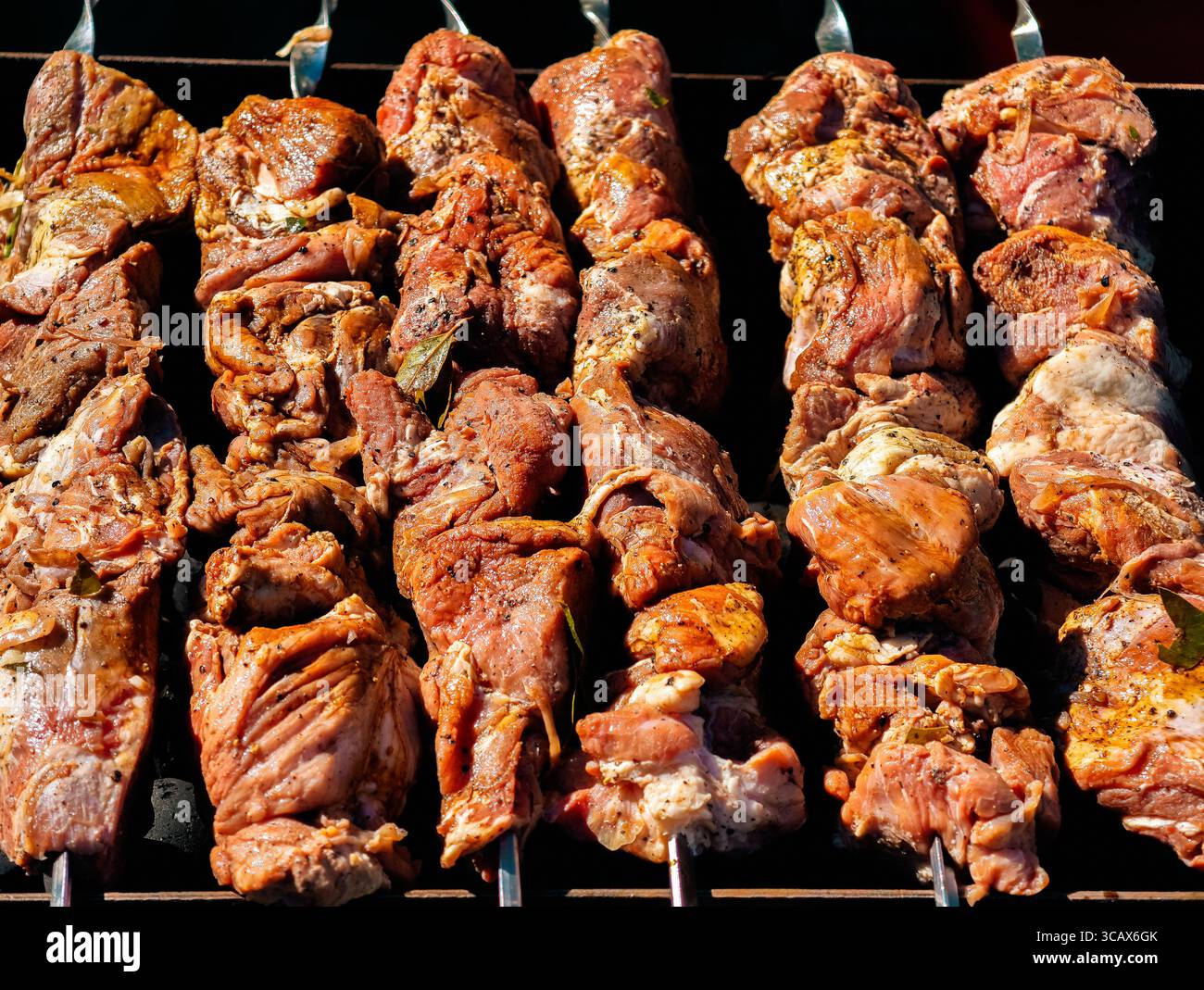 Gegrillte Fleischspieße kochen perfekt. Köstliches mariniertes Barbecue auf Spießen. Hochauflösendes Bild ideal für Hintergrundbilder, digitales Marketing, soziale Medien und kulinarische Köstlichkeiten Stockfoto