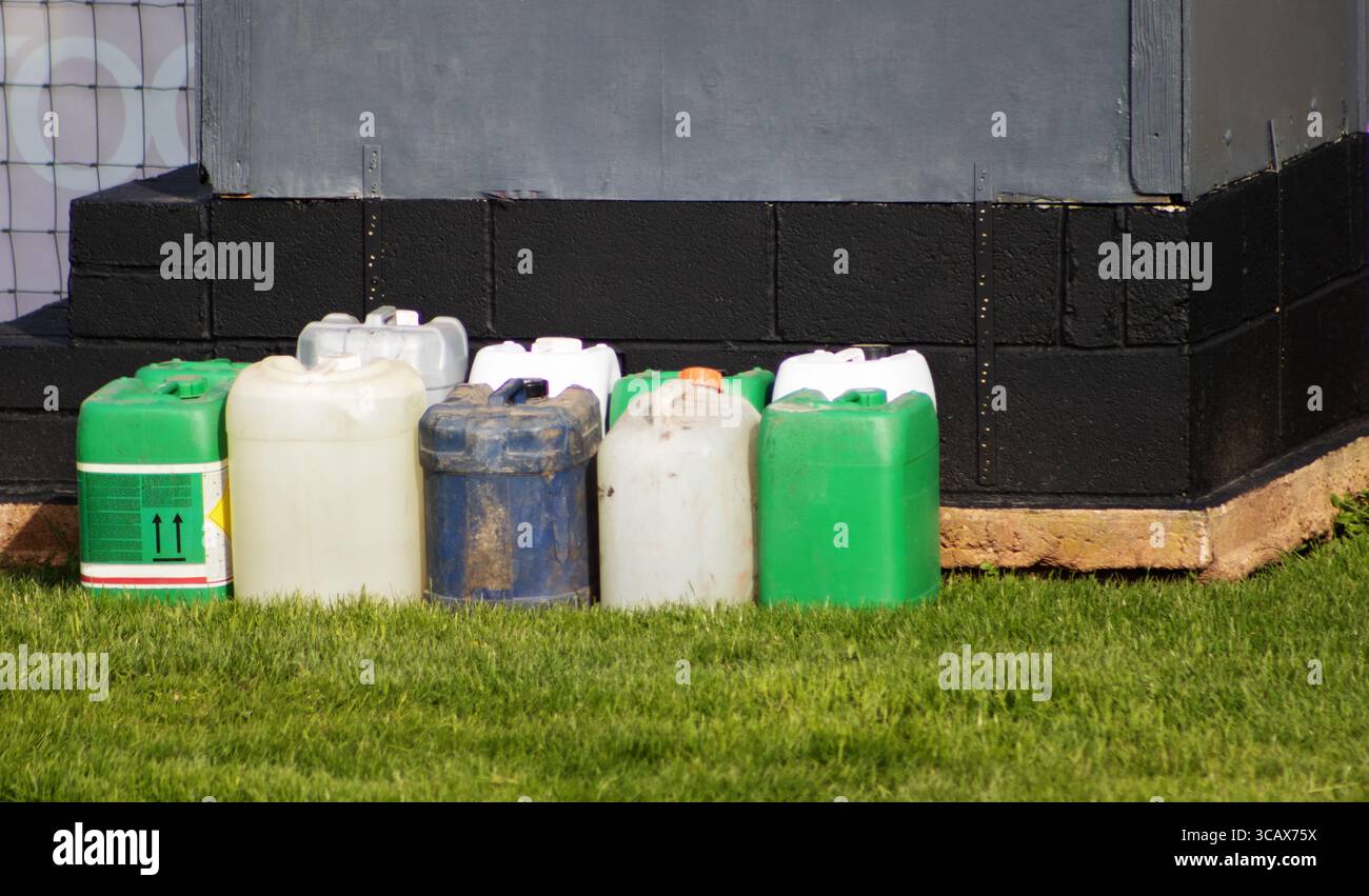 Zwei Reihen alter Chemikalienbehälter aus Kunststoff wurden umfunktioniert Stockfoto