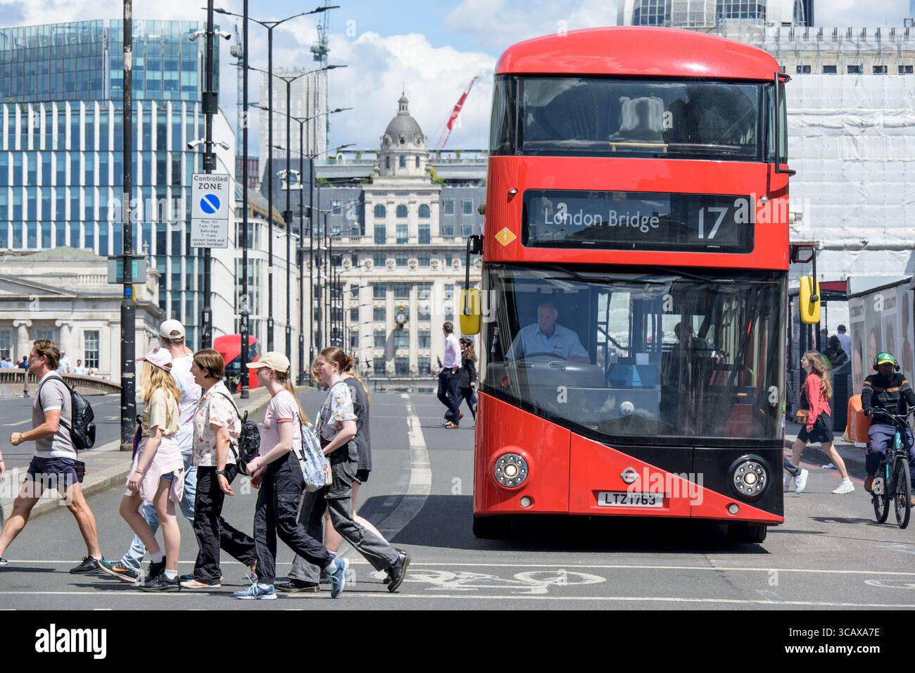 London, Großbritannien. Roter Doppeldecker Routemaster Bus Nr. 17 zur London Bridge, Überquerung der London Bridge Richtung Süden. Personen auf dem Fußgängerübergang davor Stockfoto