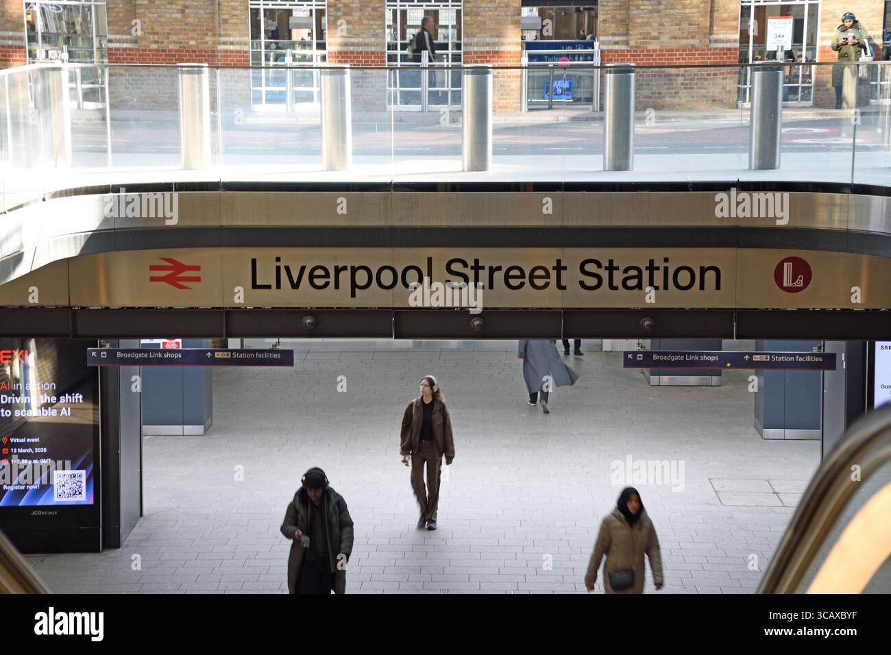 Eingang, Liverpool Street Station, City of London, London, UK - zentrale Halle, Leute laufen herum, Rolltreppe geht unterirdisch zum Concours Stockfoto